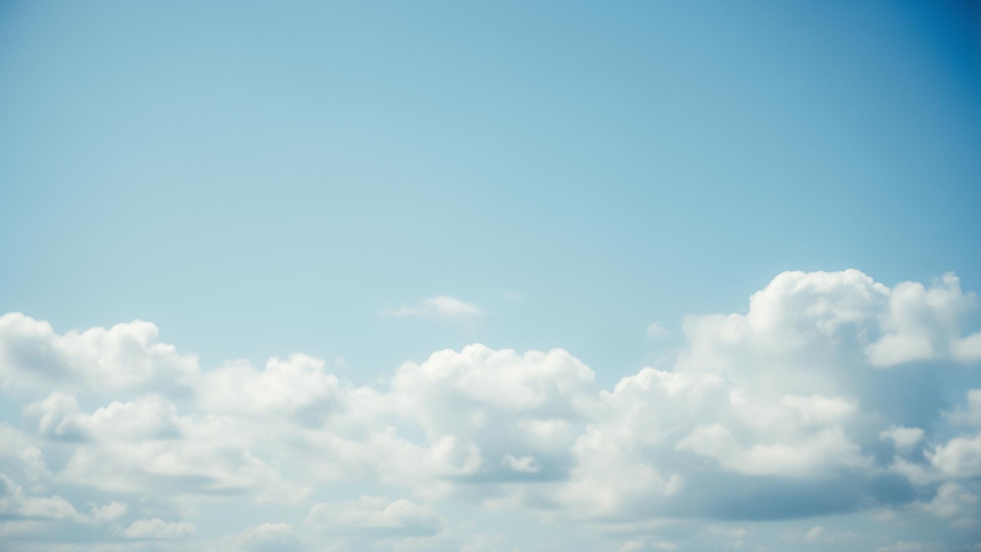 Soft blue sky with cumulus clouds